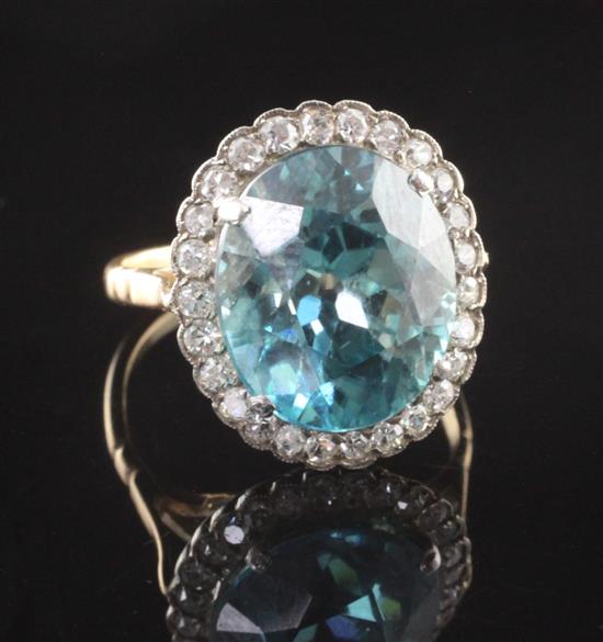 A gold, blue zircon and diamond set oval cluster ring, size M.